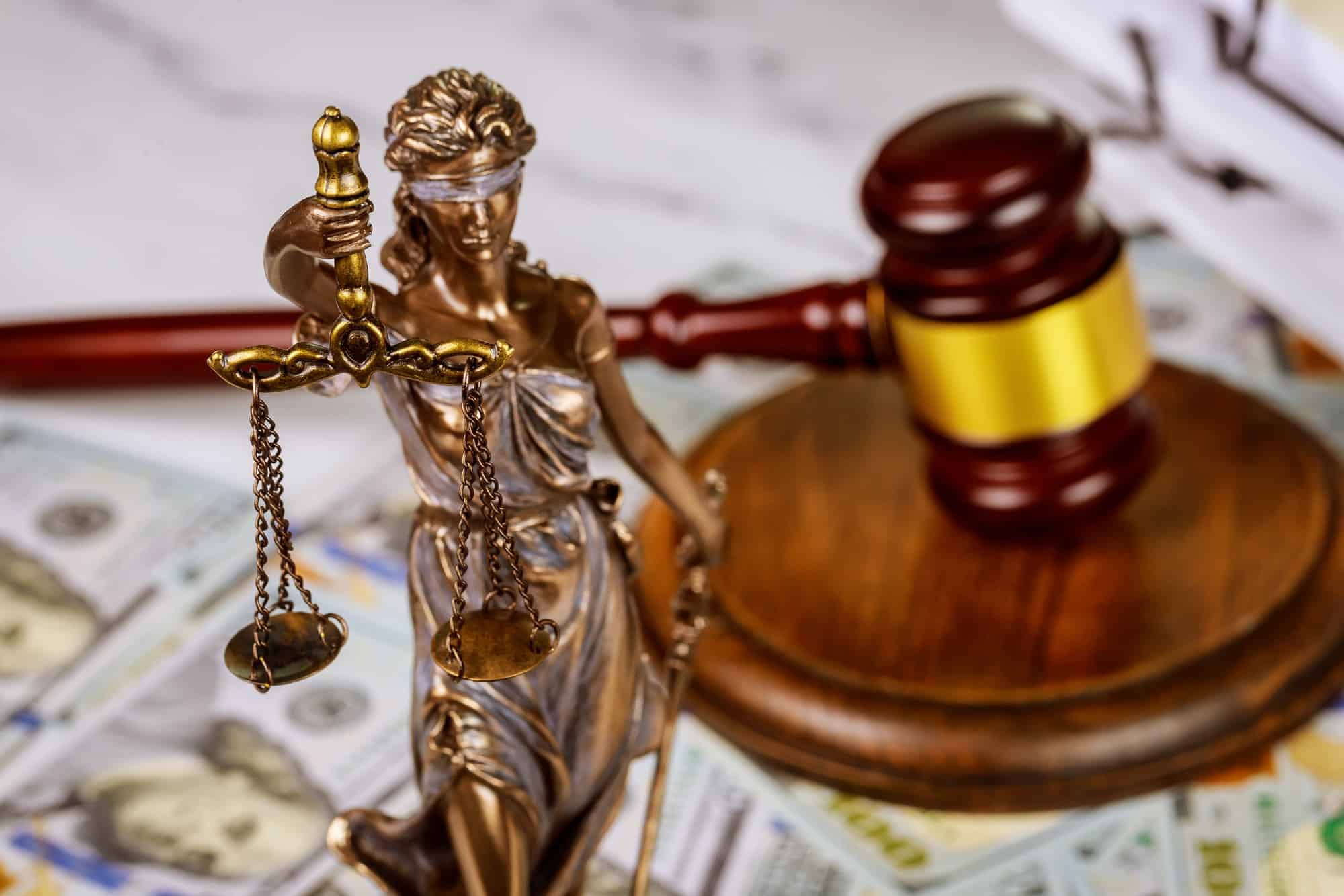 Judge's gavel with books and statue of Justice scales on law office working law document